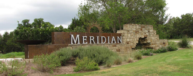 entrance to meridian neighborhood that shows a large sign and a landscaped plant bed