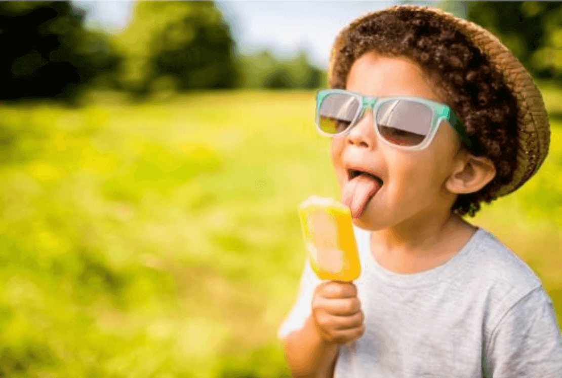 Little boy licking a popsicle